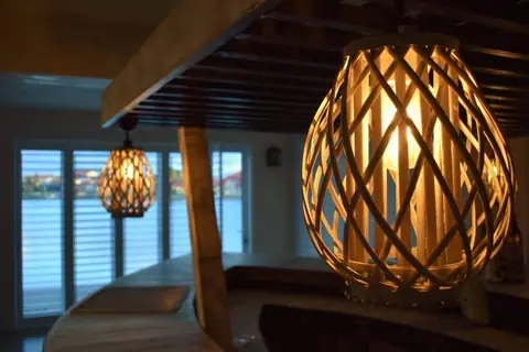 Woven pendant lamp above the bar, with the marina beyond