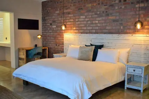 King bed against an exposed brick wall