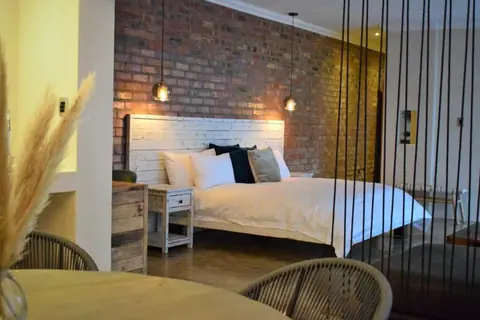 Bedroom with a king bed and woven armchairs