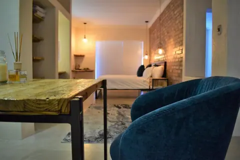 Suite seen past a desk and a teal velvet chair